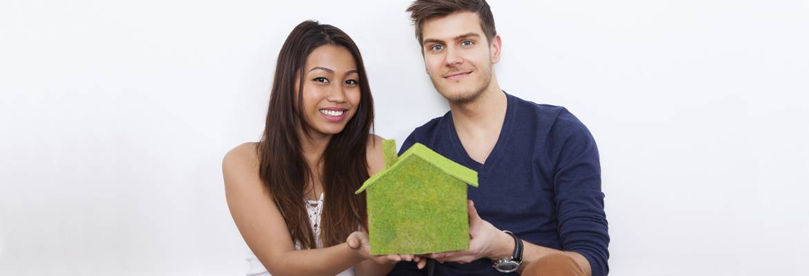 Couple Holding Green House Model At New Home